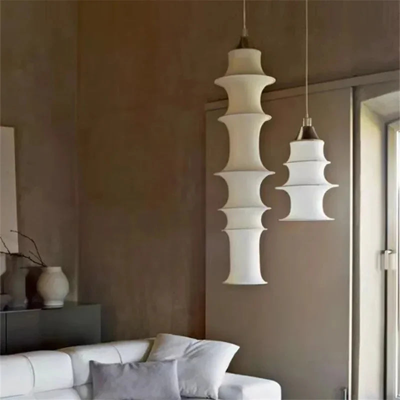 Stacked silk pendant lit in a hallway with plaster walls