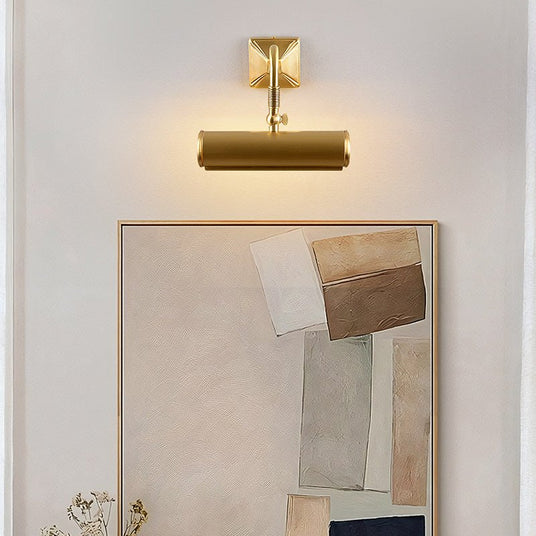 Brass tube lit over a large framed artwork resting above a console