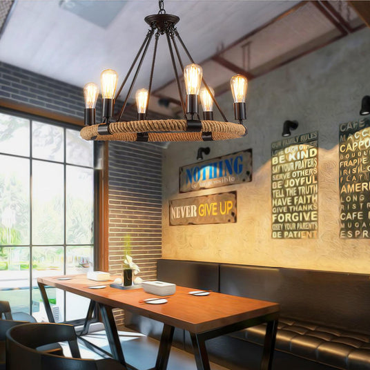 Chandelier lit above a long wood table in a room with tall windows