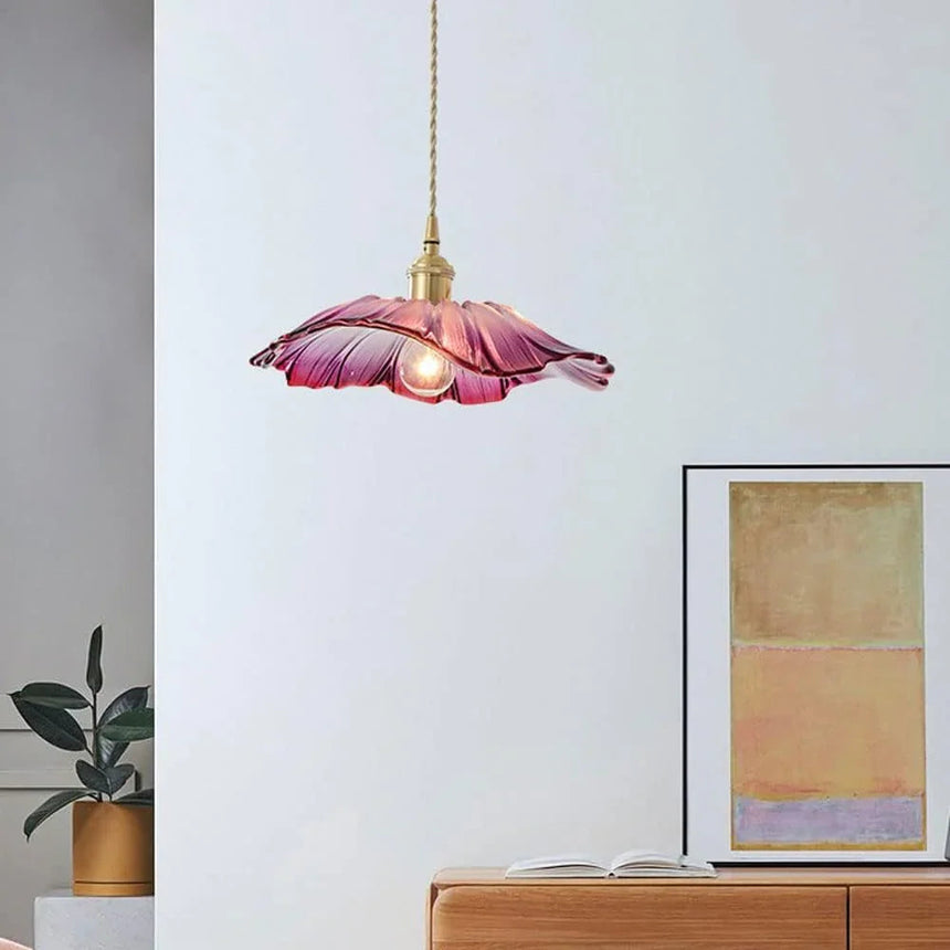 A purple lotus shade hung above a wooden cabinet beside a framed picture