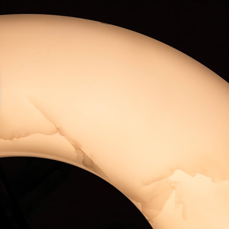 The curve of the lit stone ring, veining showing through the alabaster