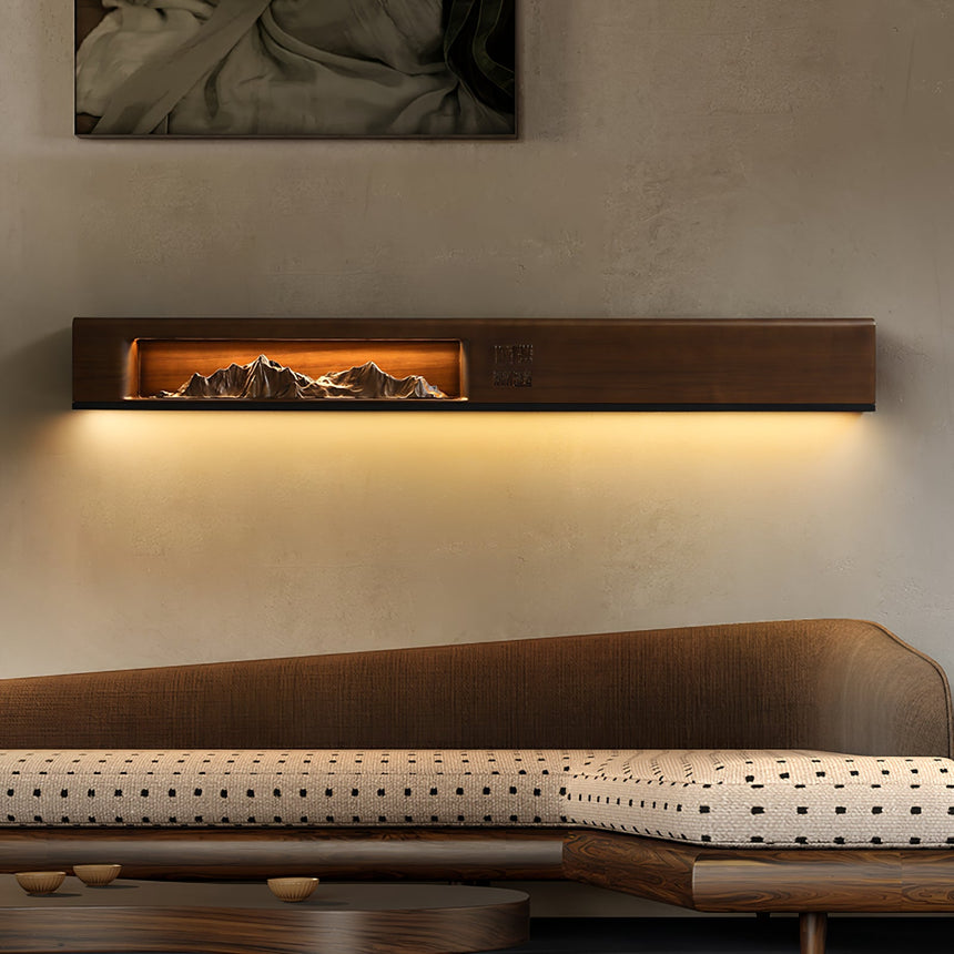 Walnut panel lit above a long low daybed in a plain room