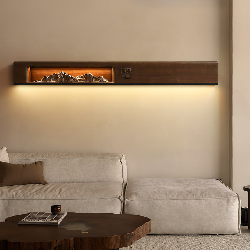 Walnut panel lit above a pale sofa, washing the wall behind it