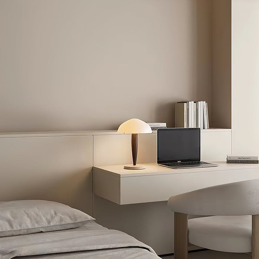 Marble base table lamp on a built in desk in a pale bedroom