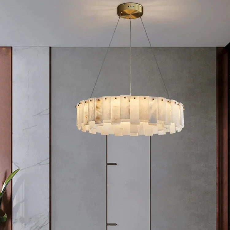 Marble chandelier in a copper ring hung against a pale wall