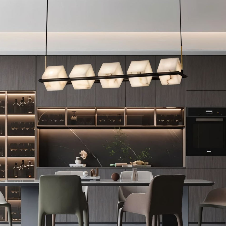 Lit stone cubes above a kitchen counter with stools and a wine wall behind