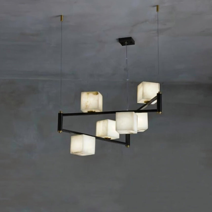 Lit alabaster cubes on staggered black arms against a smooth concrete wall