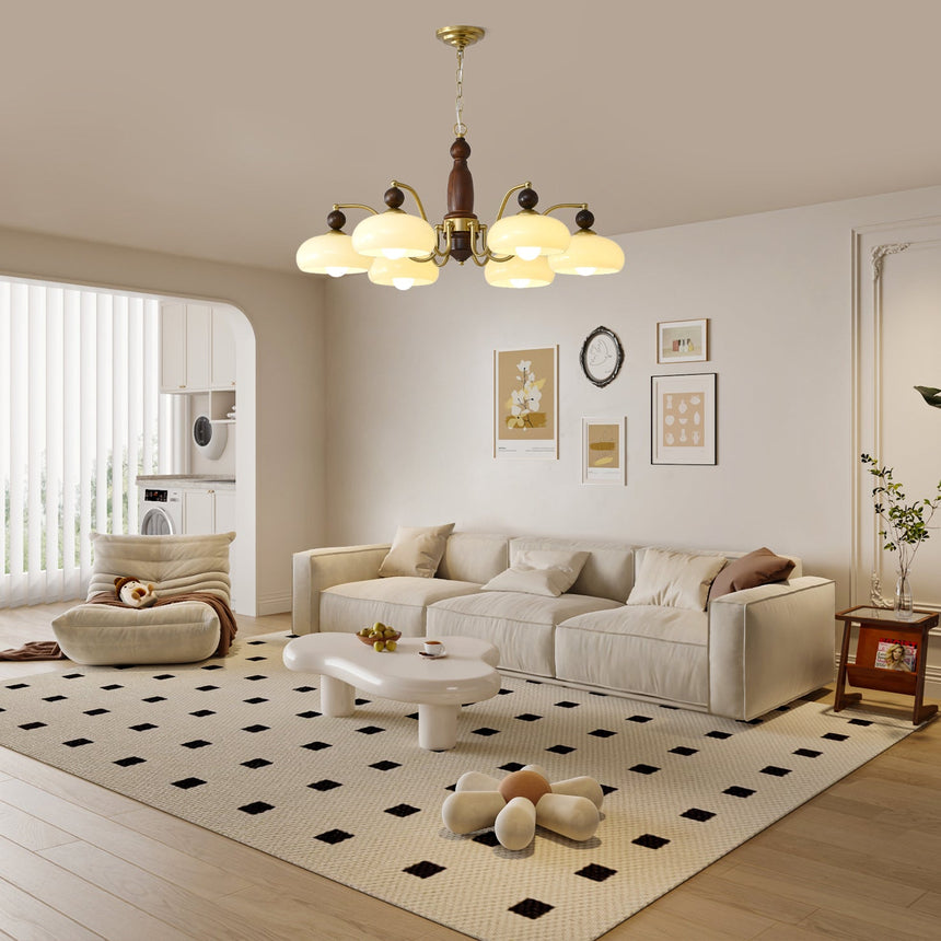 The fitting lit above a patterned rug and a pale sofa group