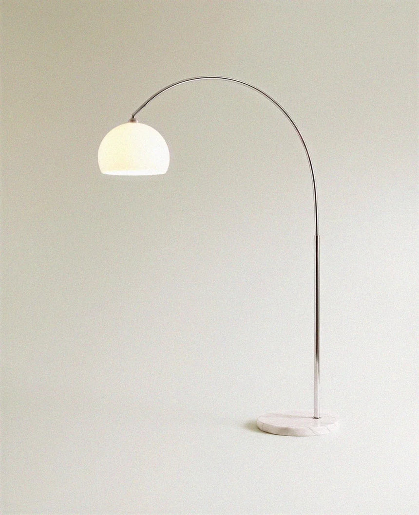 The glass dome unlit in cream, held by the chrome arm above the stone base