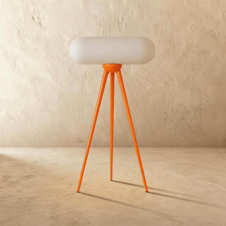 The orange tripod unlit, the capsule shade resting across the top of the legs