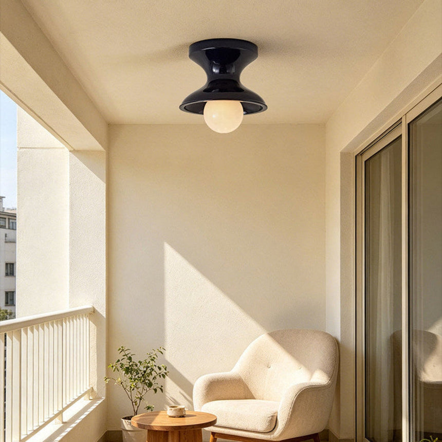 Navy spool ceiling light on a landing beside a window and a curved chair