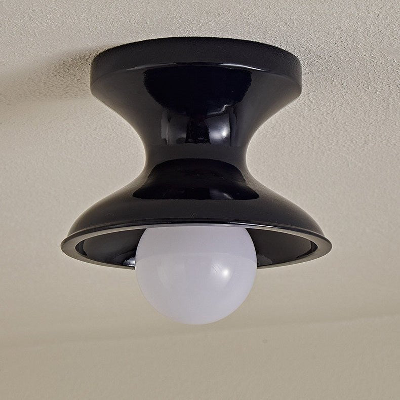 Close view of the navy spool ceiling light with a round opal globe
