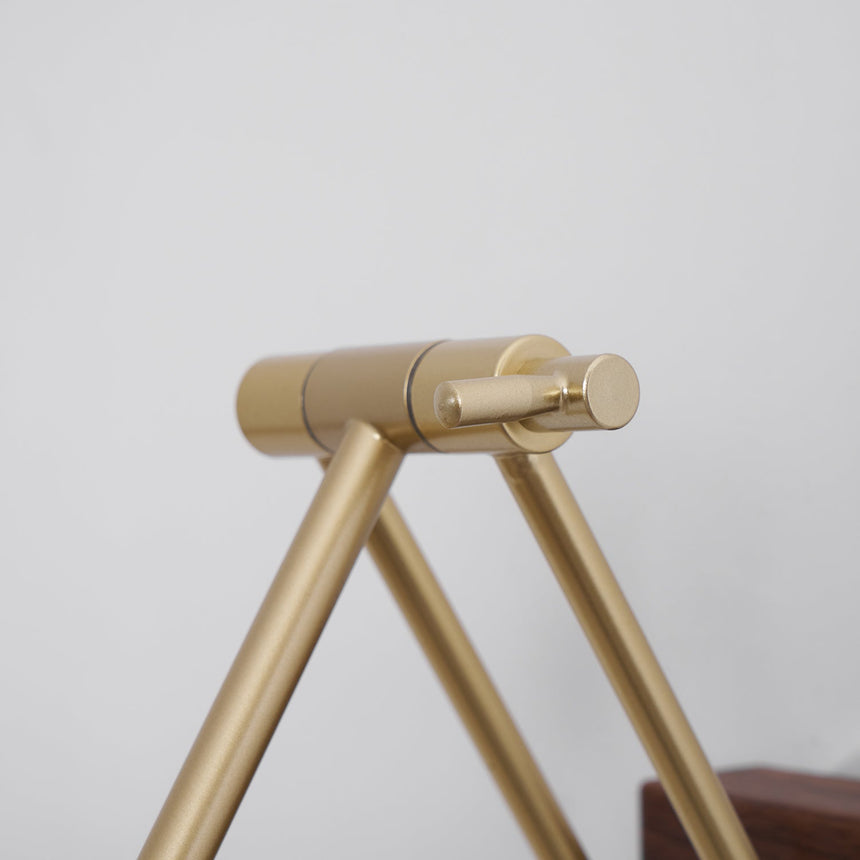 Close view of the brass scissor arm and the knurled joints that set its angle