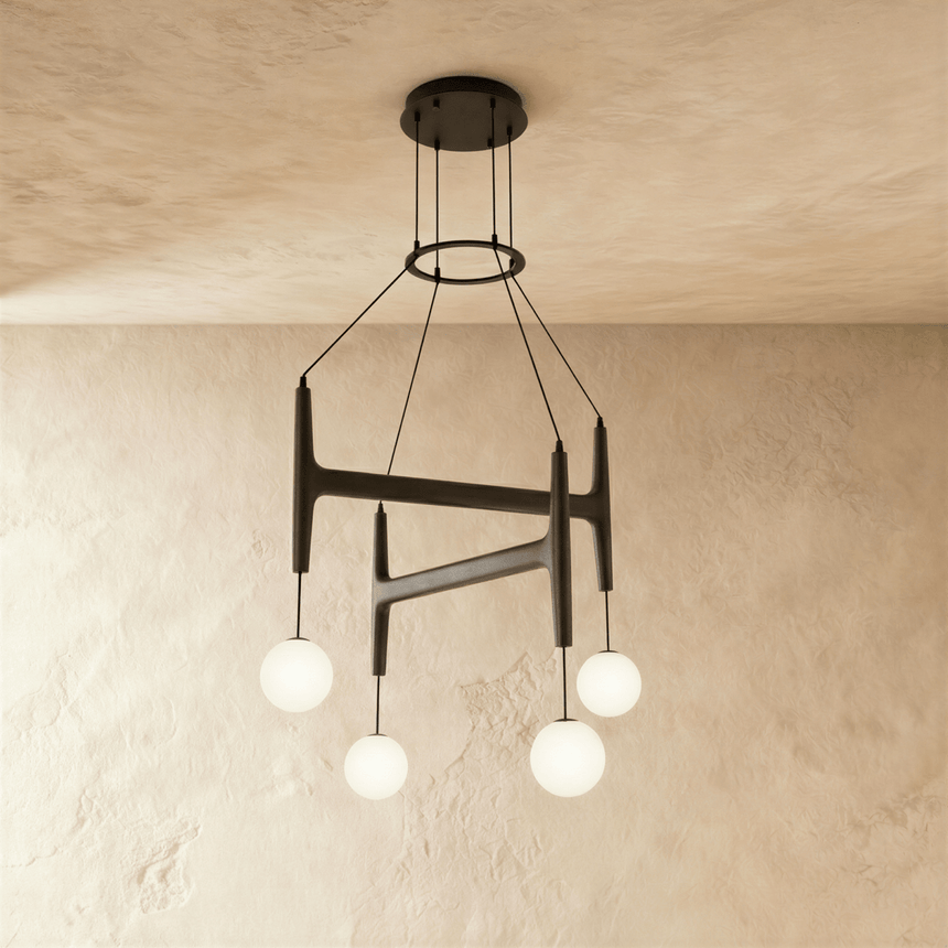 The same crossed bar frame in black wood carrying four lit milk glass globes