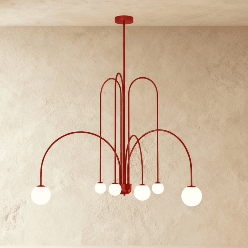 The red frame turned so the arched arms cross above the lit opal globes