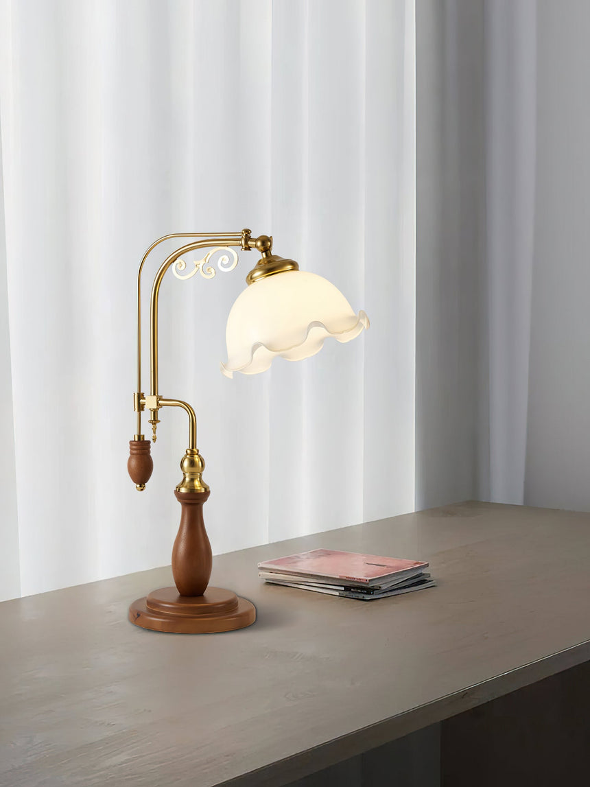 Brass arch lamp lit on a gray surface in front of a white curtain