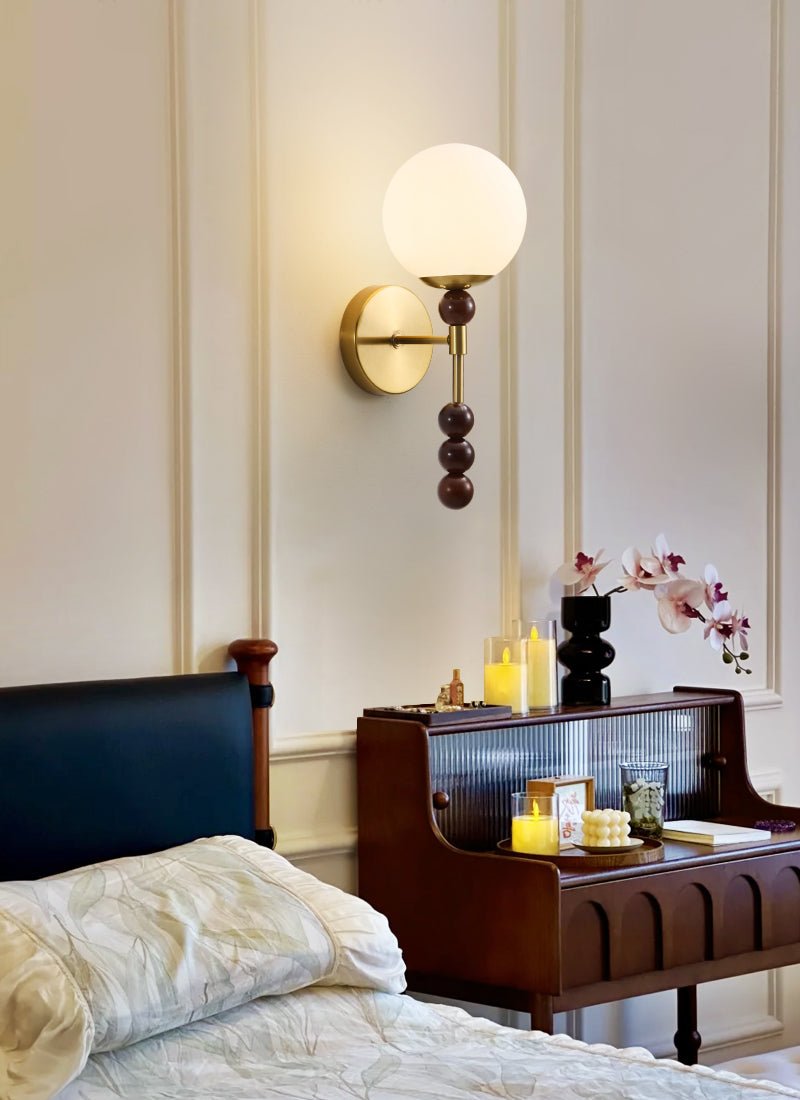 Milk glass globe lit at night above a bed and a lit glass cabinet