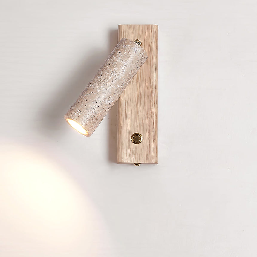 Travertine tube lit on a light wood plate with the button switch below