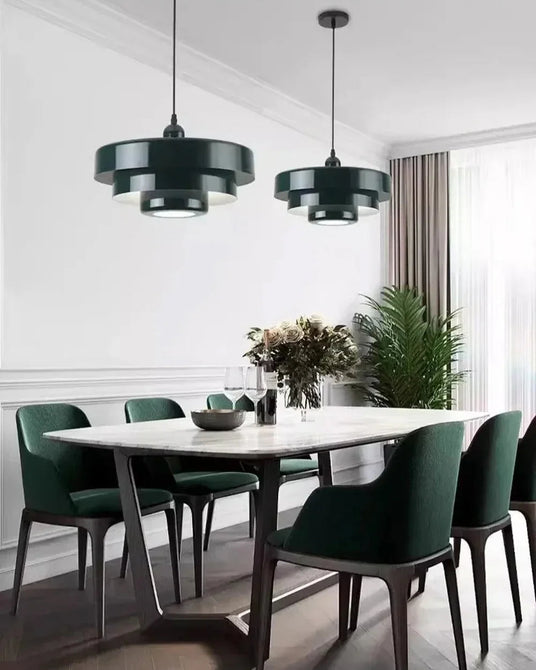 Green layered shades above a dining table in a pale room