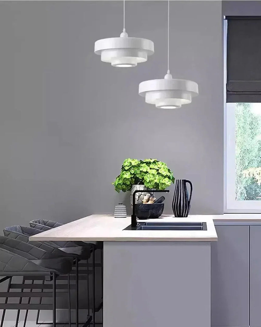 White layered shades above a kitchen island