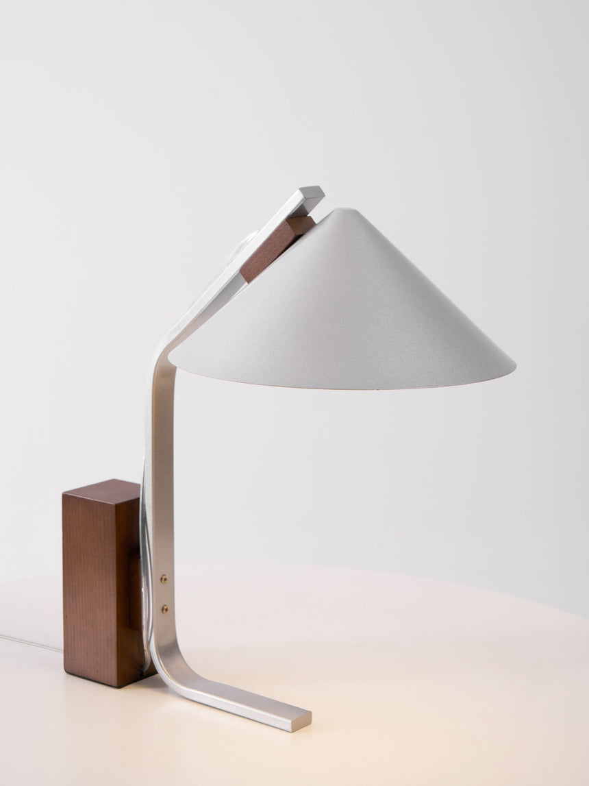 Minimalist desk lamp seen from the side, the arc curve in profile