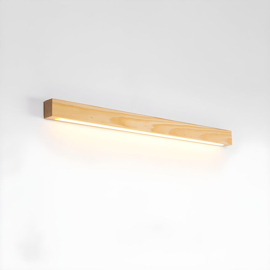 Light pine picture light bar lit against a plain pale wall