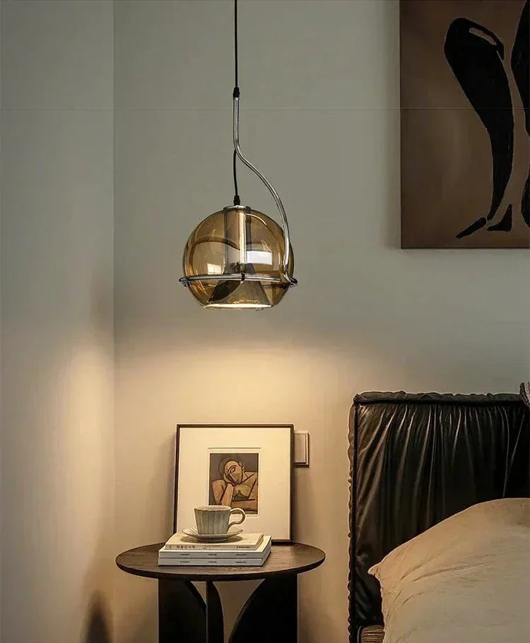 The globe lit beside a framed picture above a round bedside table