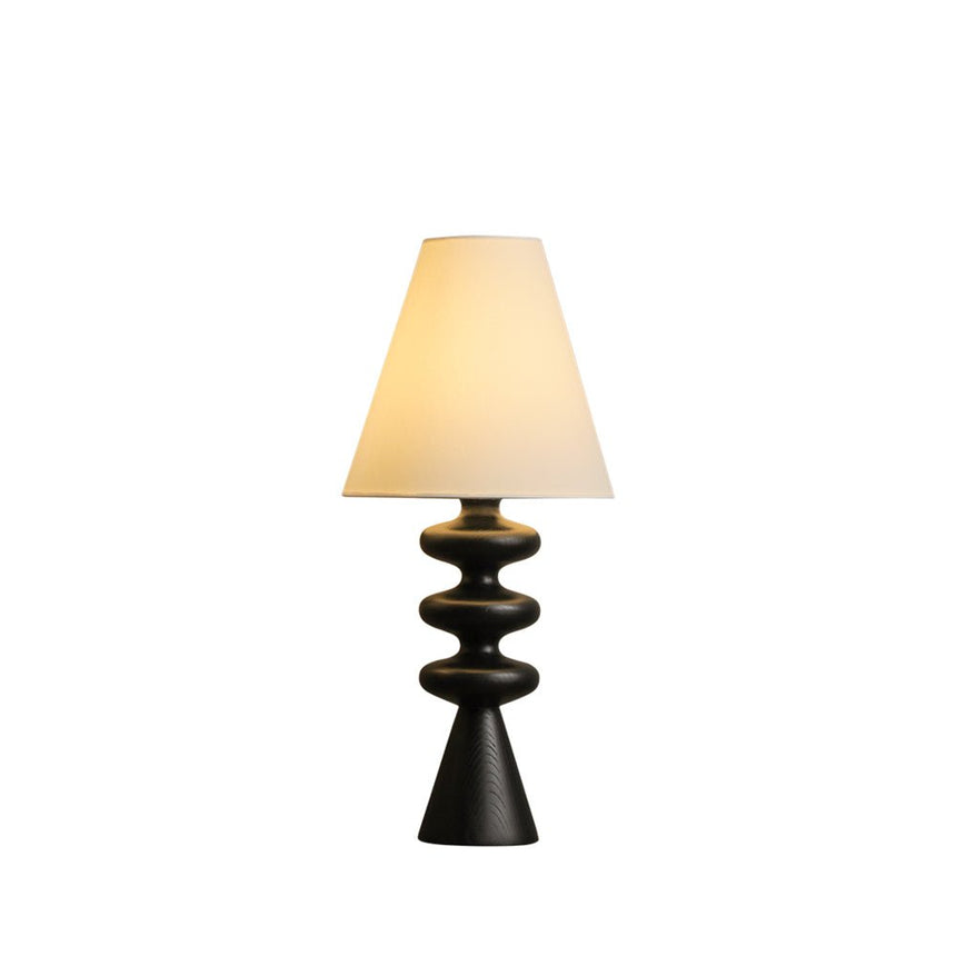Rippled base table lamp in black against a plain white ground
