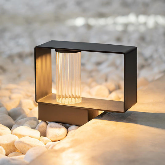 The low wide body lit on white pebbles beside a concrete terrace