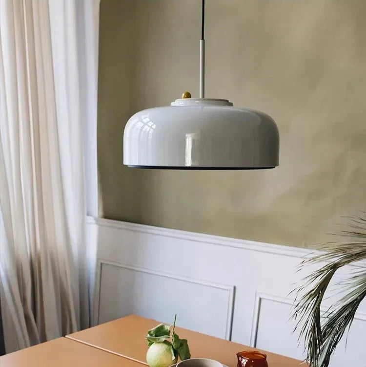 Gray honeycomb mesh pendant hung above a table by a curtained window