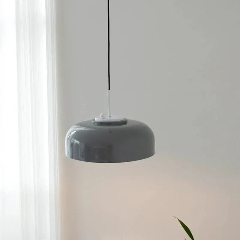 Gray pendant lamp seen against a pale wall, showing the rounded shade profile