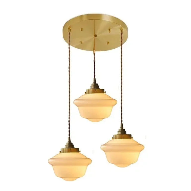 Three opal shades dropped at staggered lengths from a round brass canopy