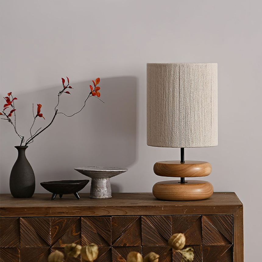 Black pebble nightstand table lamp beside two dark ceramic vases