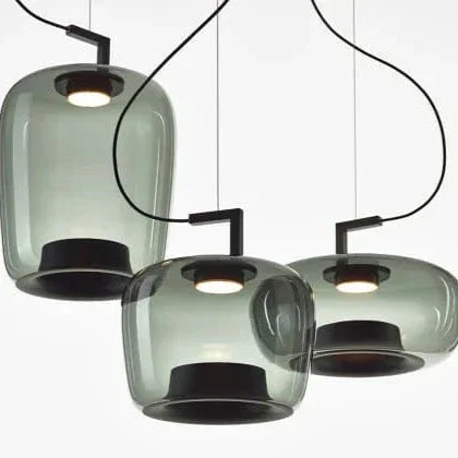 Green and amber glass shades hung together against a light wall
