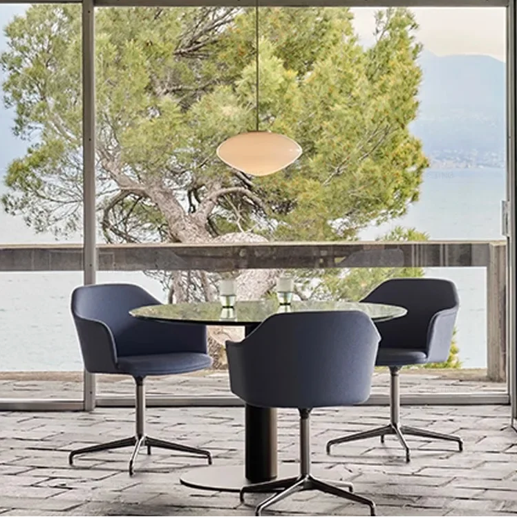 The pebble shade lit above a round table with blue armchairs around it