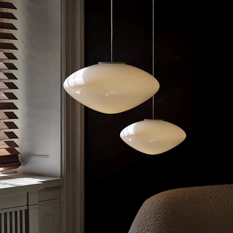 Two opal pebble shades lit at different heights in a dark room