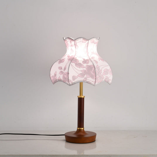 Pink blossom shade lamp lit, the panels glowing softly