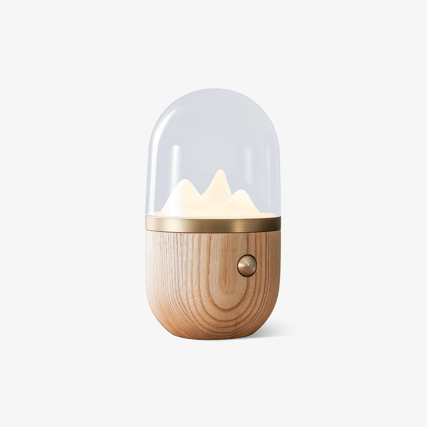 Nursery table lamp with a glowing mountain under a clear dome, plain background