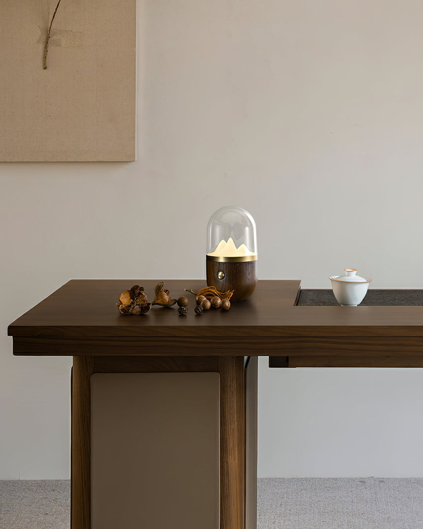 Nursery table lamp lit on a dark dining table beside a small bowl