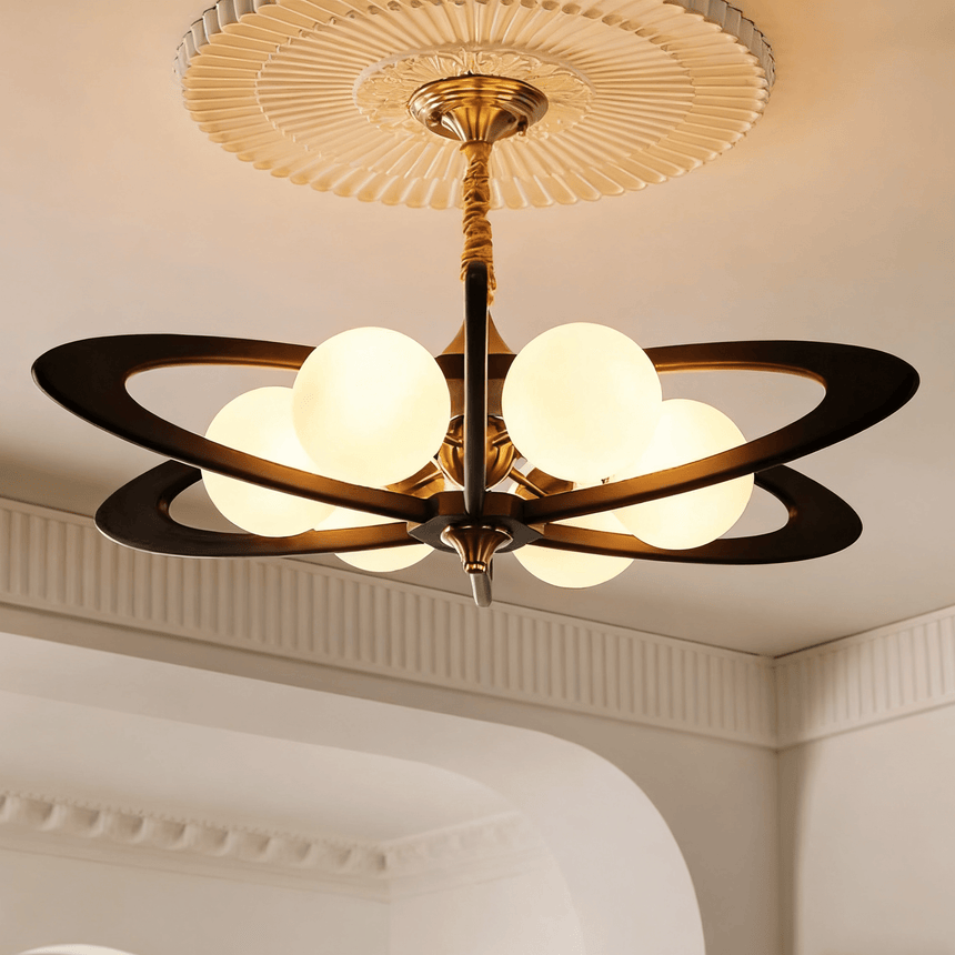 Chandelier lit in a bedroom above a bed with a wood panel wall behind