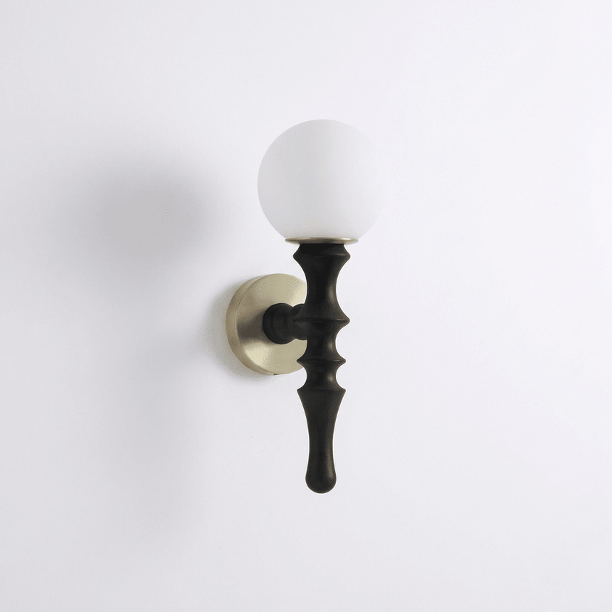 The black stem seen from the front, the white orb bright against the wall