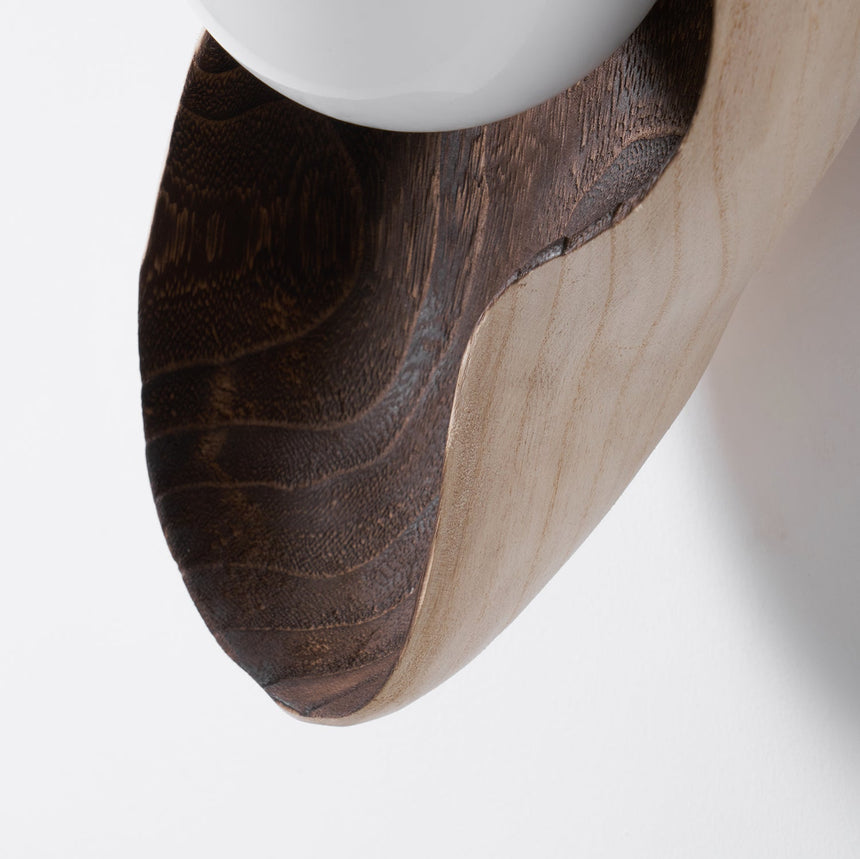 Close view of the pale wood meeting the dark walnut along the curve