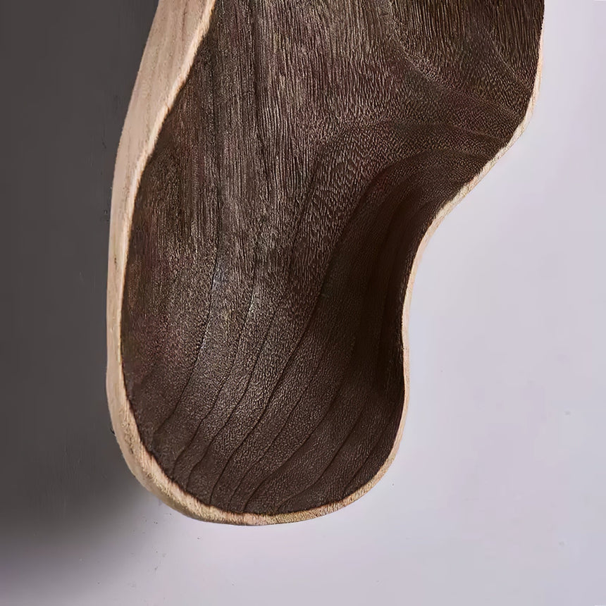 Close view of the dark walnut grain running along the carved body