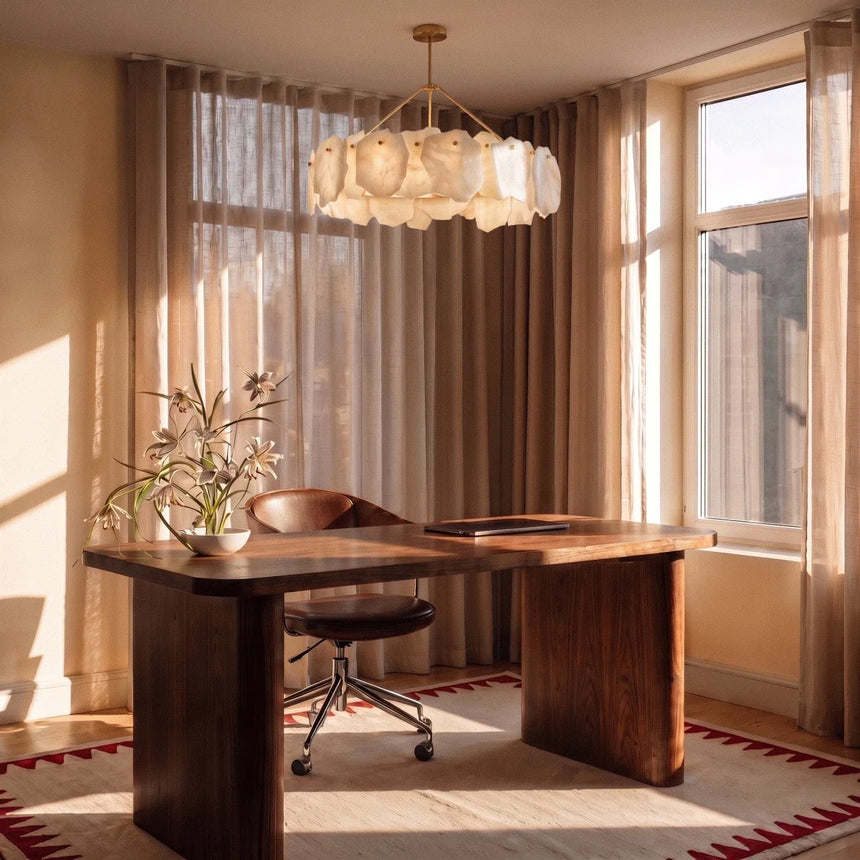 A petal ring lit above a timber desk beside a window and curtains