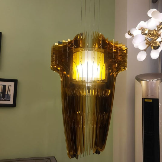 The amber version lit against a green wall beside a framed print and a cabinet