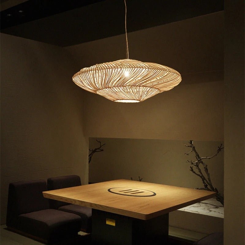 The black shade lit beside a paneled window with a low table and cups below