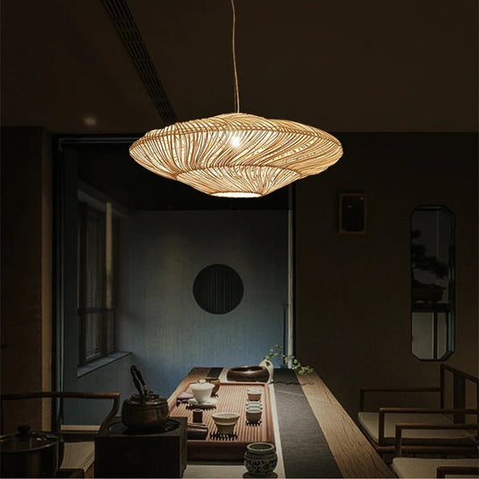 The shade lit above a long low table set for tea in a room with wood screens