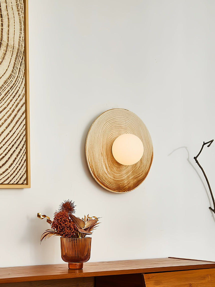The sconce above a low console beside a framed print