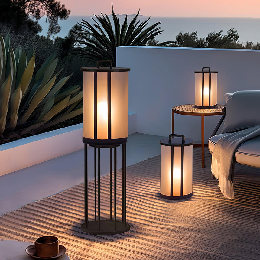 Lanterns lit on a white terrace beside agaves and a low garden wall