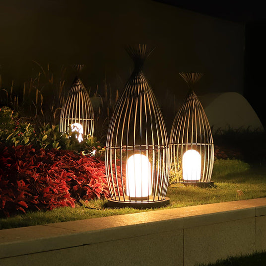 Three lit together on a low wall ledge beside red leaved planting